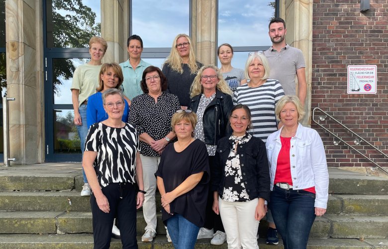 OGS and ÜMI care team standing on a staircase.