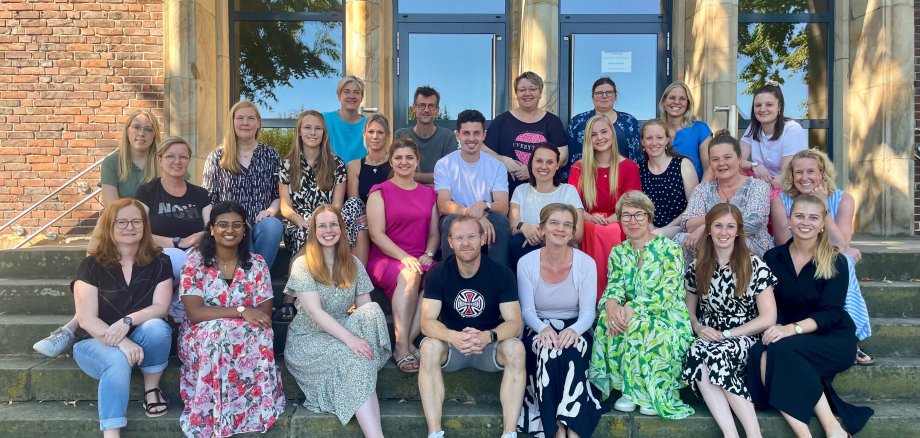 The teaching staff of the Eilermark School sitting on a staircase.