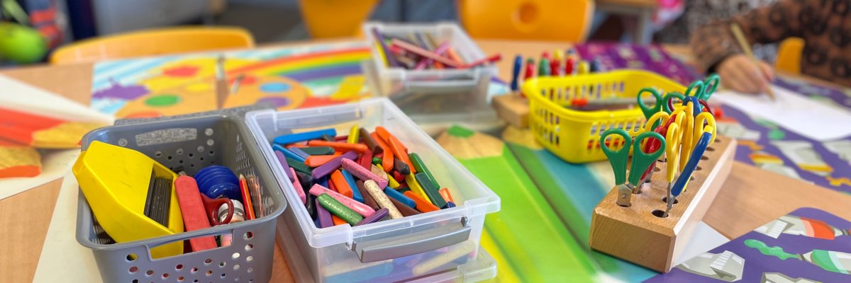Children painting with wax crayons.