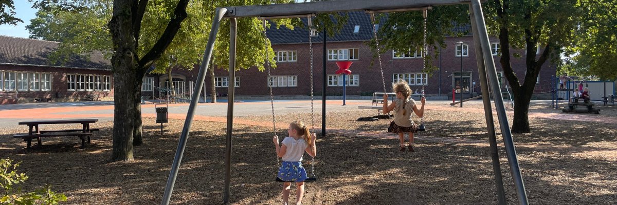 The schoolyard with a swing and seating area under the trees. The schoolyard with a swing and seating area under the trees.