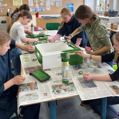 The children paint objects for the beehive in the bee workshop