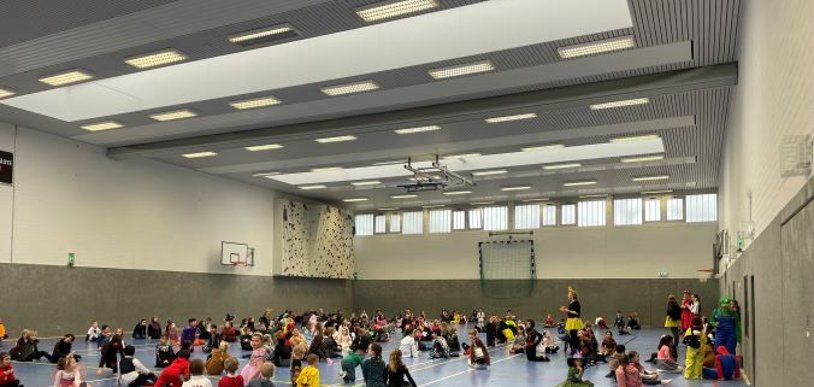 Lots of children with colorful costumes in the sports hall.