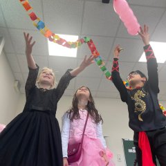 Children celebrate carnival in the classroom and throw a balloon into the air.