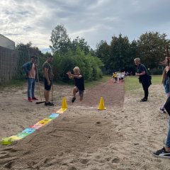 Children do a long jump.