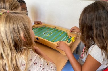 Niños jugando al "futbolín"