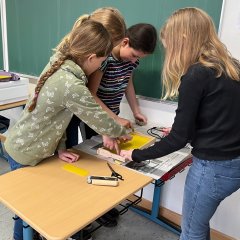 A gyerekek tárgyakat festenek a méhkaptárhoz a méhész műhelyben