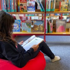肘掛け椅子でゆったりと読書する子供。