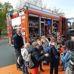 Brannvesenet med en brannbil i skolegården