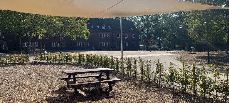 Een rustige zithoek op het schoolplein om te ontspannen onder een luifel.