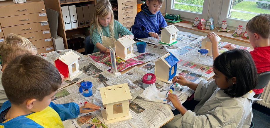 Kinderen maken vogelhuisjes tijdens het adventsknutselen.
