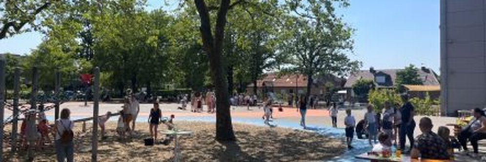 Schoolplein met veel mensen op het feest van de eerstejaars leerlingen.