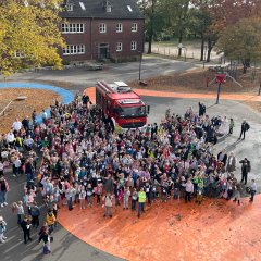 Alle kinderen van de EIlermark School van bovenaf gefotografeerd vanuit het raam.