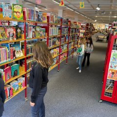 Die Kinder suchen sich Bücher aus in der Bücherei.