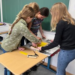 Die Kinder streichen für den Bienenstock Gegenstände in der Bienen AG