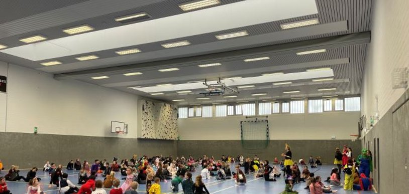 Viele Kinder mit bunten Kostümen in der Sporthalle.