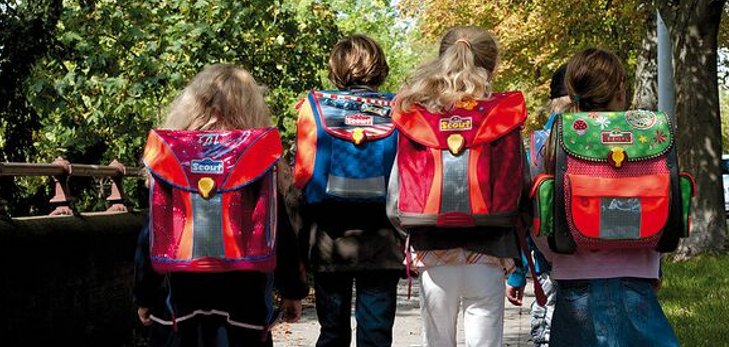 Kinder laufen zu Fuß zur Schule.