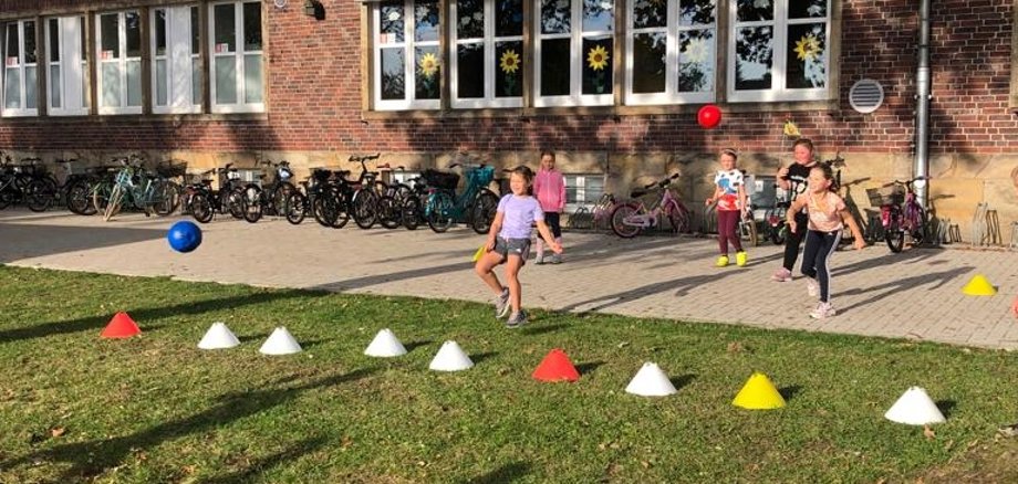 Sportfest - Kinder spielen Zweierball gegeneinander. 